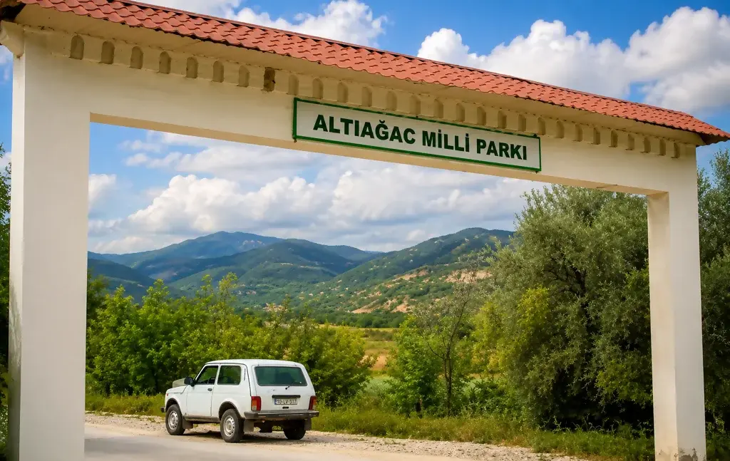 Главный вход в Алтыагаджский национальный парк с надписью ALTIAGAÇ MİLLİ PARKI, на фоне горного пейзажа Азербайджана